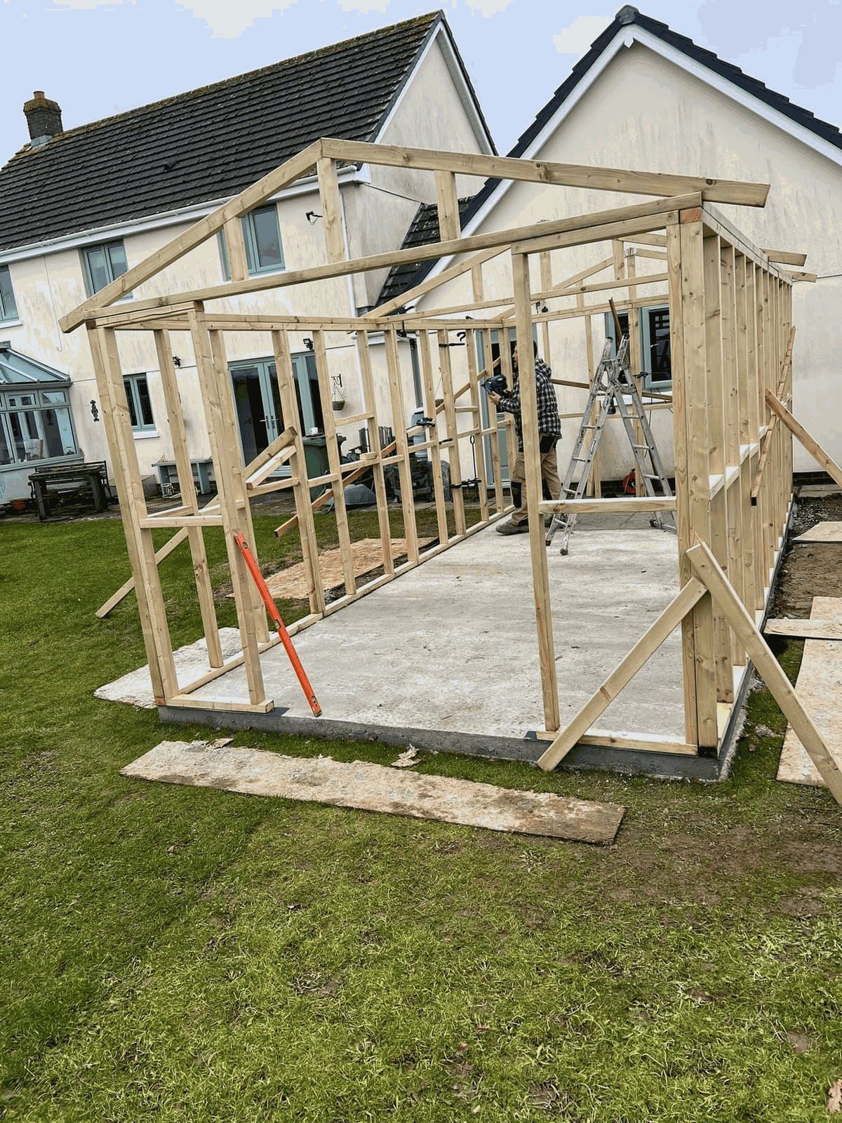 A garden room's timber frame going up on a concrete base