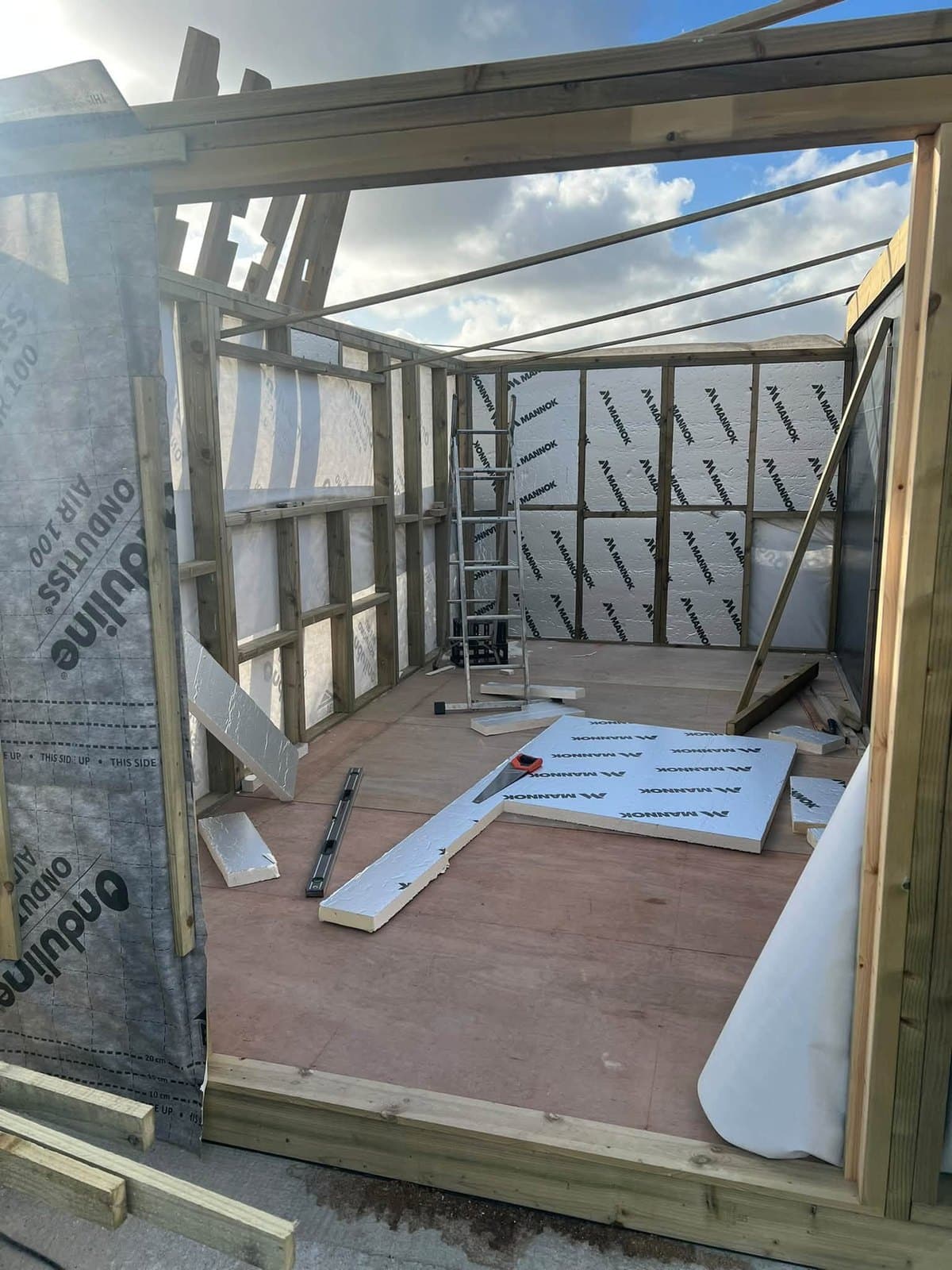 Insulation boards and a breathable membrane going into a garden room's timber frame