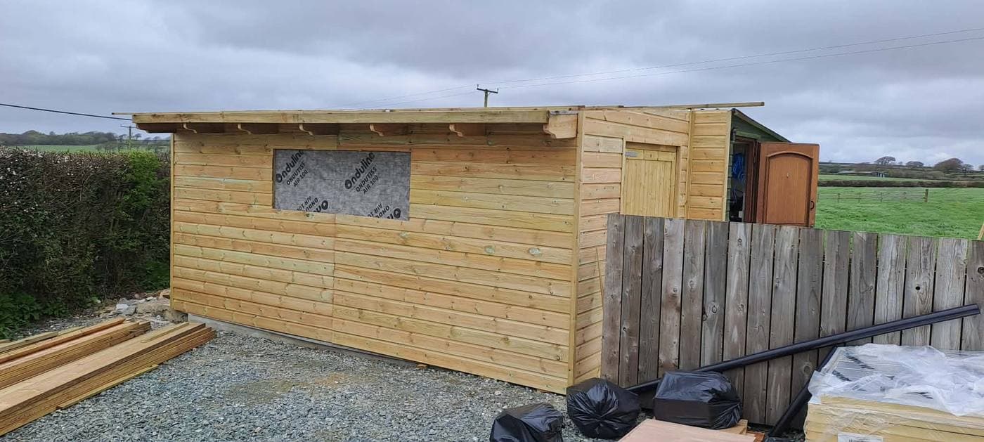 A long timber garden building with a window, built on site by Inside and Out Maintenance, North Devon