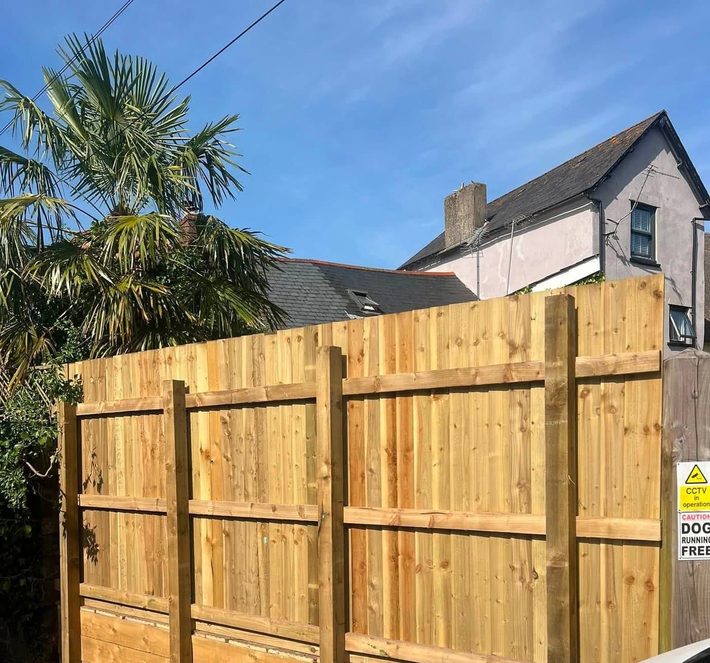 A tall close-board fence on new gravel boards, built against a driveway